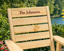 Load image into Gallery viewer, Wooden chair with 'The Johnsons' engraving in a garden setting.